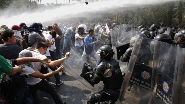 Policías y manifestantes en Venezuela