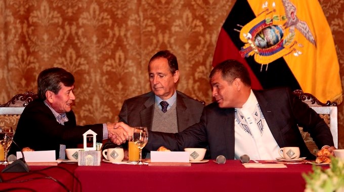 Un dirigente del ELN, a la izquierda, da la mano a Rafael Correa.