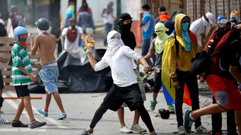 Manifestantes atacando a la policía con cócteles molotov