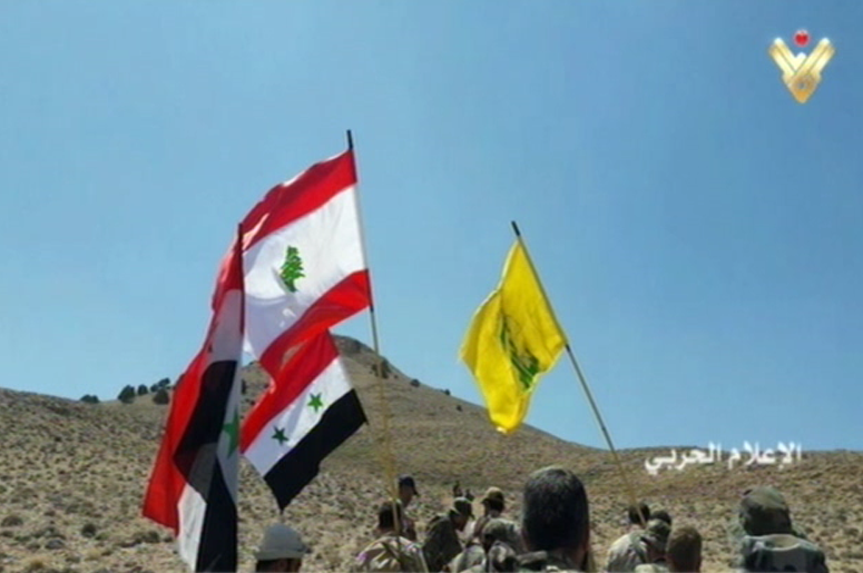 Los soldados vencedores con banderas de Siria, Líbano y Hezbolá