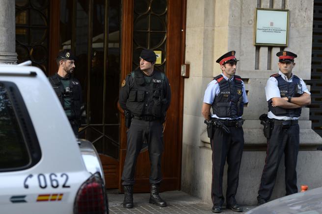 Guardias civiles y policías catalanes en la puerta de uno de los edificios del gobierno catalán