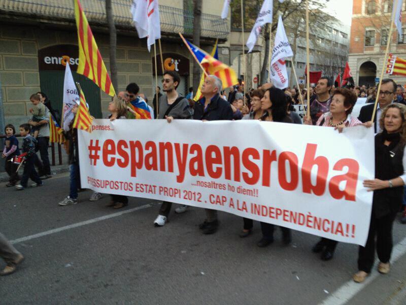 Unos manifestantes catalanes llevan una pancarta que dice "España nos roba".