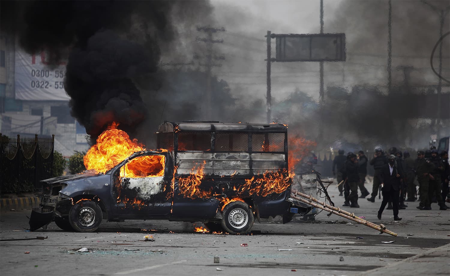 Policías cerca de un vehículo incendiado por los manifestantes.