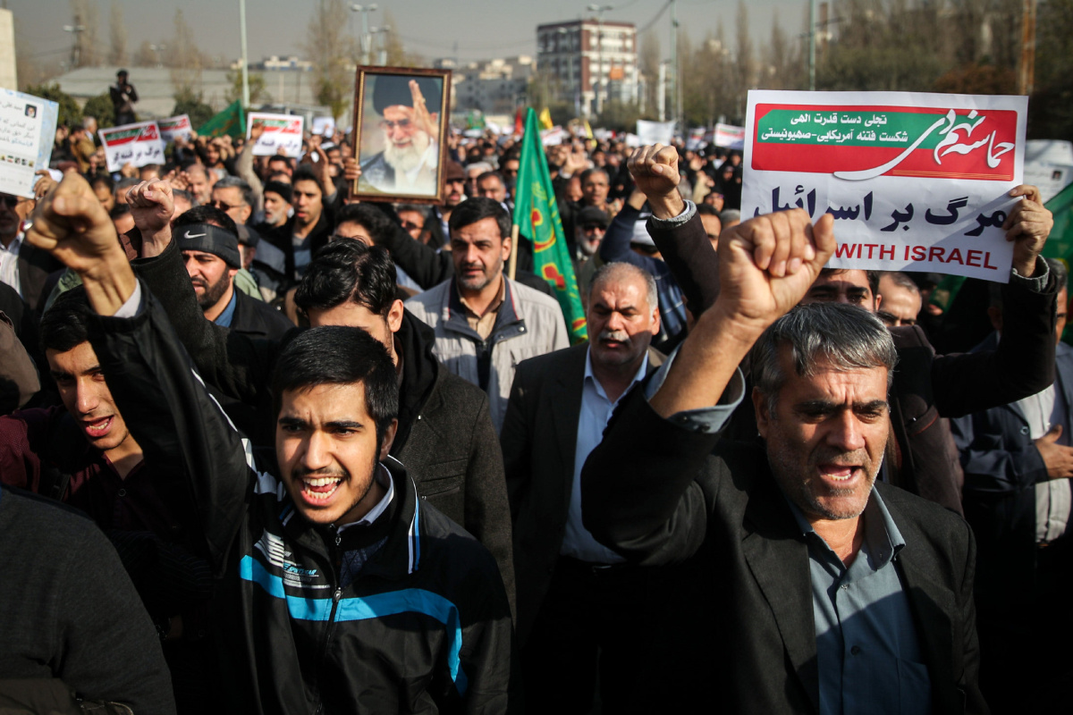 Manifestantes iraníes con fotos de Jomeini y carteles donde se lee "abajo con Israel"