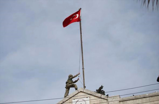 Un soldado turco iza la bandera turca en Afrin