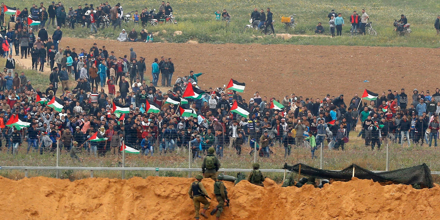 Manifestantes palestinos ante la valla y los soldados israelíes