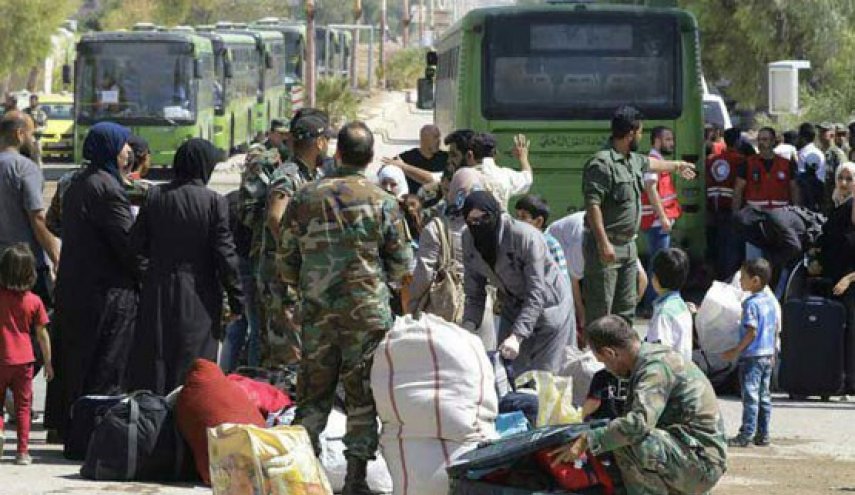 Los milicianos y sus familias suben a los autobuses