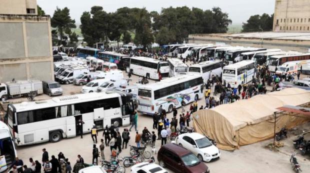 Autobuses esperando para llevar a los milicianos al norte de Siria