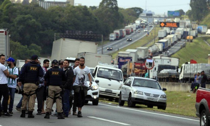 Policías hablando con camioneros en una autovía cortada