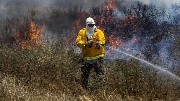 Un hombre apagando un incendio causado por una cometa