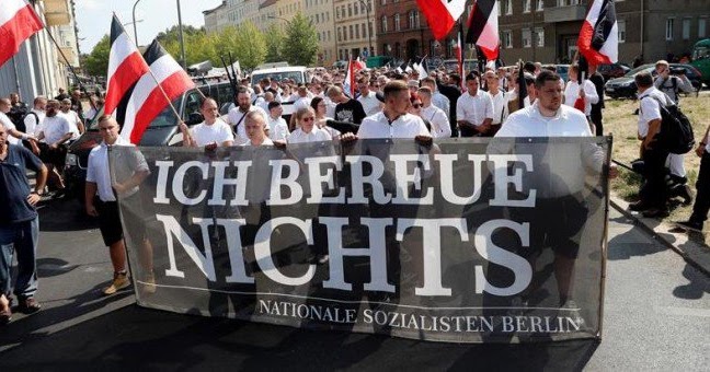 Manifestantes reivindicando a Rudolf Hess en Berlín, con una pancarta que dice "No me arrepiento de nada"