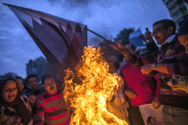 Manifestantes egipcios quemando una bandera catarí