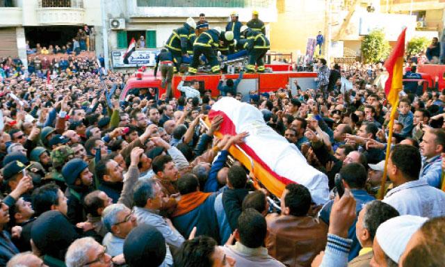 La multitud lleva el cadáver de una víctima del atentado de ayer