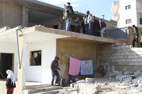 La gente mira en el lugar donde impactó un obús en el pueblo de Arsal, en Líbano