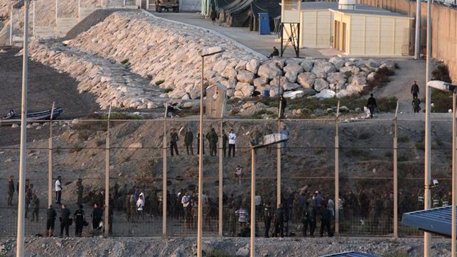 Inmigrantes y policías a ambos lados de la frontera, en Ceuta, España