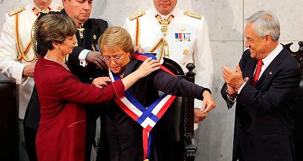 Michelle Bachelet-centro-recibe la banda presidencial de Isabel Allende-izquierda-en presencia de Piñera-derecha-.