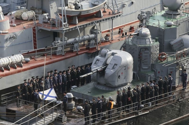 Marinos izando la bandera de la armada rusa en un barco en el puerto de Sebastopol, en Crimea.