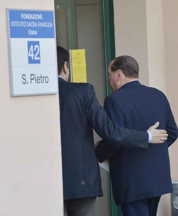 Silvio Berlusconi, de espaldas, a la derecha, entrando en el centro.