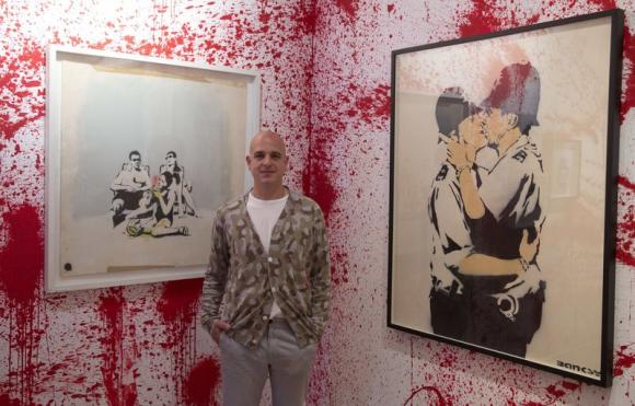 Steve Lazarides posa ante algunas obras de Banksy