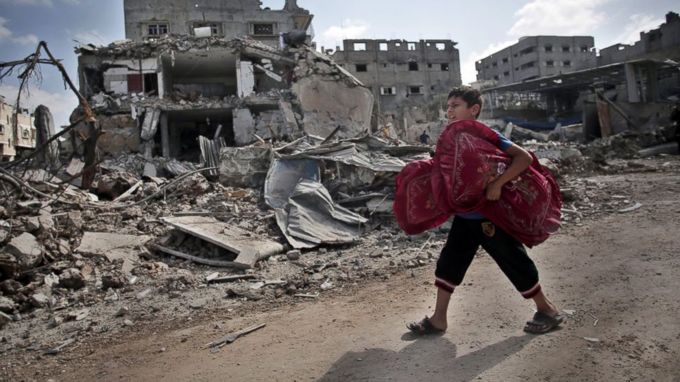 Un niño lleva almohadas en el barrio de Shujaia durante el alto el fuego Un niño lleva almohadas en el barrio de Shujaia durante el alto el fuego