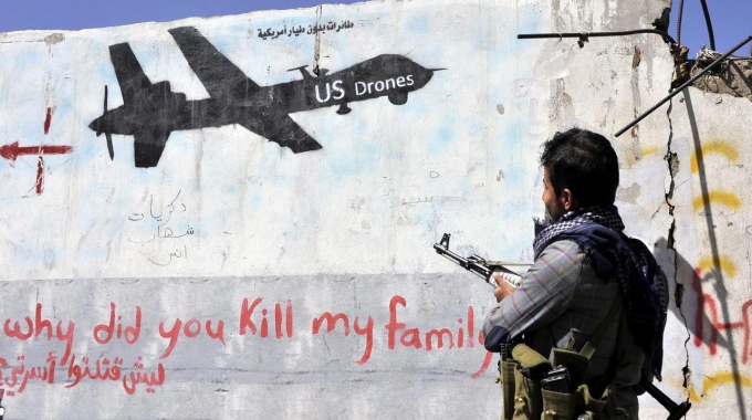 Un miliciano huthi mira a un mural que pregunta ¿porqué has matado a mi familia? a los aviones sin piloto estadounidenses Un miliciano huthi mira a un mural que pregunta ¿porqué has matado a mi familia? a los aviones sin piloto estadounidenses