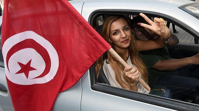 Una tunecina con la bandera de su país Una tunecina con la bandera de su país