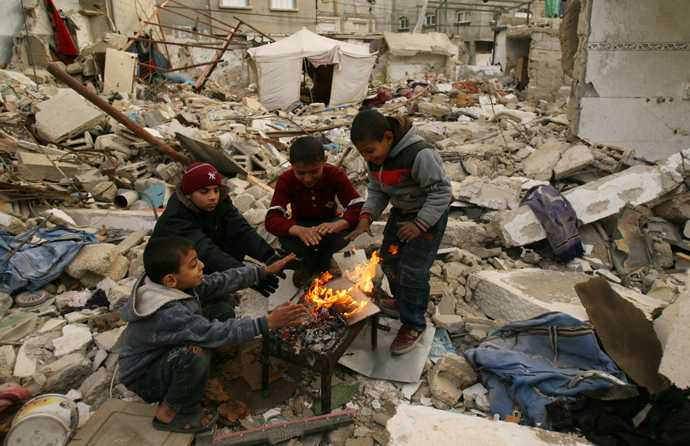 Unos niños se calientan con fuego en Gaza Unos niños se calientan con fuego en Gaza