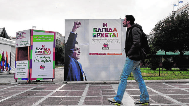 Un griego pasa ante un cartel electoral de Syriza