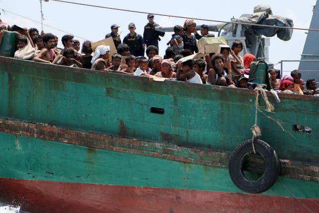 Los migrantes, siendo remolcados por la marina tailandesa para sacarlos del país