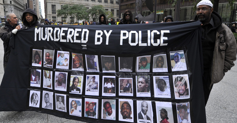 Unos manifestantes llevan una pancarta con fotos de negros asesinados por la policía