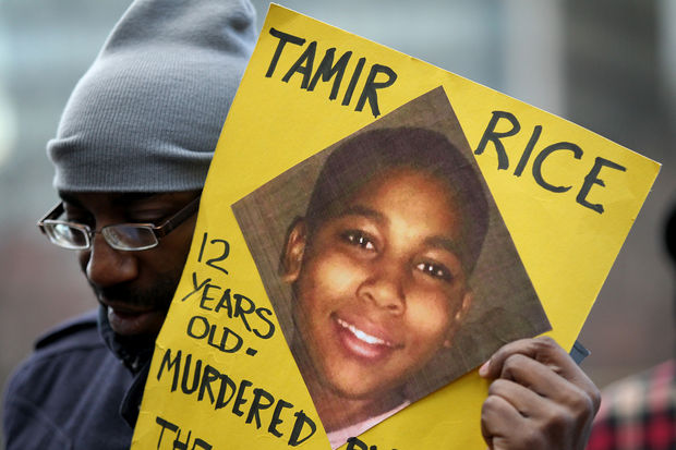 Un manifestante lleva una foto de Tamir Rice