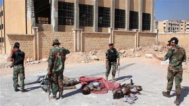 Soldados sirios miran los cadáveres de combatientes del estado islámico en Alepo