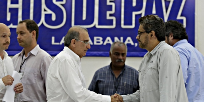 El negociador del gobierno, Humberto de la Calle-a la izquierda-le da la mano al de las FARC, I ván Márquez