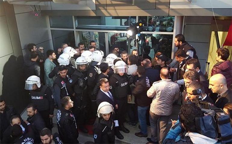 Policías y periodistas en la sede de una de las televisiones cerradas