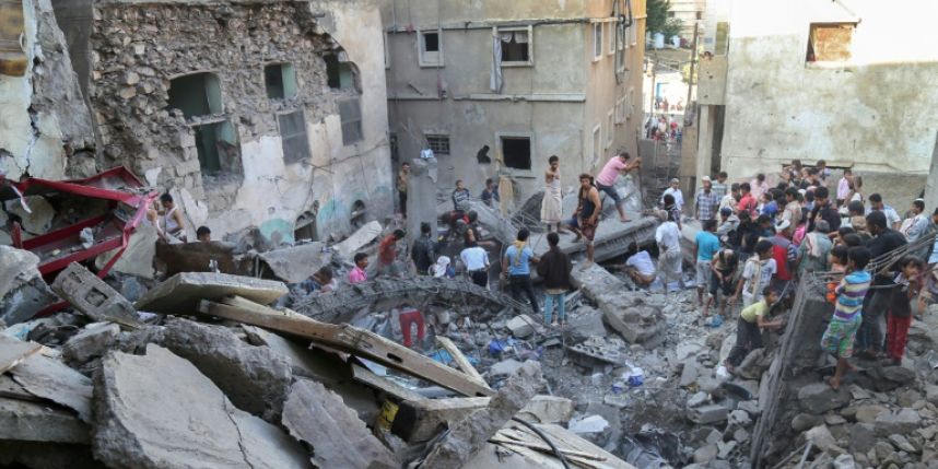 La gente del barrio miran lo que queda de un edificio en Taiz