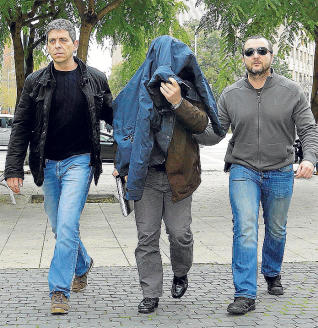 El profesor acusado, tapándose con una chaqueta al llegar a los juzgados