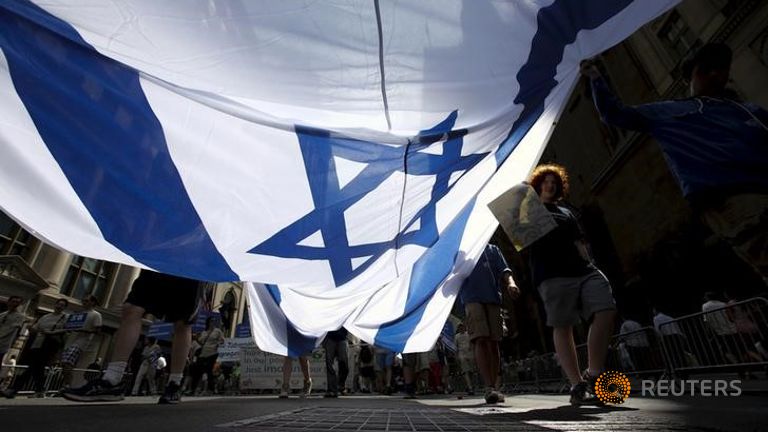 Gente llevando una bandera israelí en la marcha a favor de Israel en Manhattan