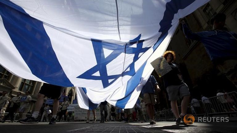 Gente llevando una bandera israelí en la marcha a favor de Israel en Manhattan Gente llevando una bandera israelí en la marcha a favor de Israel en Manhattan